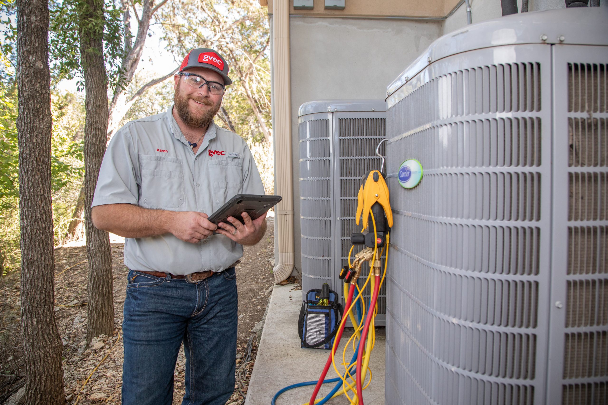 HVAC technician standing by unit